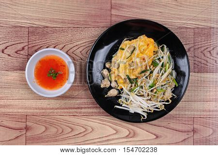 Thai food.,Fried egg and oyster with bean sprouts and shallot as Hoi Tod Khai in Thai served with chili sauce.