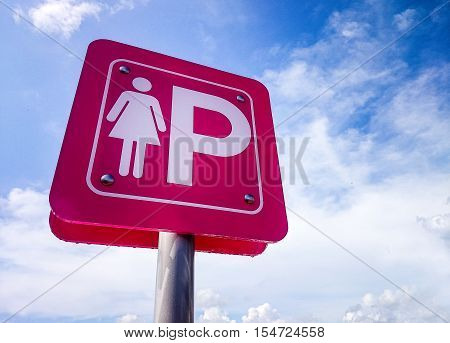 Pink parking sign for lady against the blue sky