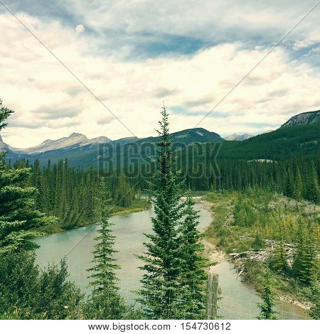 Scenic mountain landscape with river and trees in foreground.  Instagram effects.