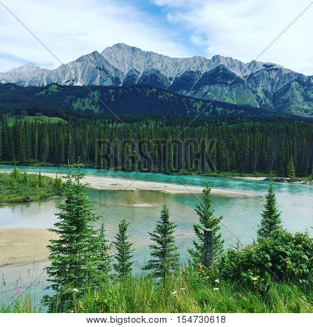Scenic mountain landscape with river and trees in foreground.  Instagram effects.