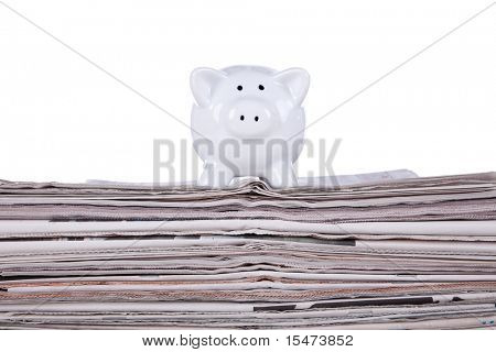 Prasátko bank přes hromadu novin (selektivní zaměření)