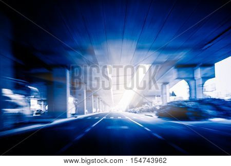 traffic under a elevated highway in blue tone.