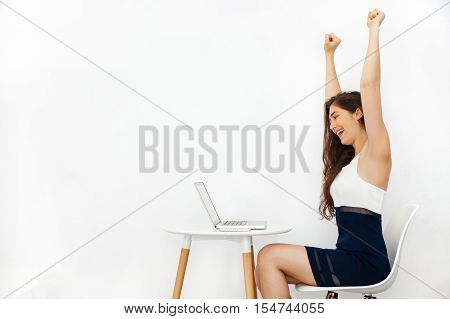 Young beautiful Caucasian woman having arms raised up as she has won over something in white isolated background with copy space