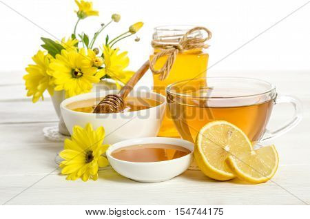 Yellow Flowers, Tea , Lemon And Honey On Wooden Table