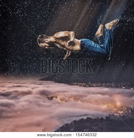 The fantasy image of male break dancer in water on dark sky background Flying over the city at night