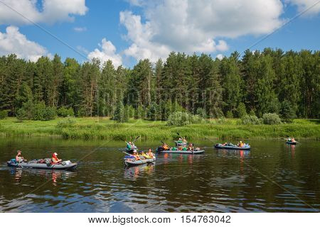TVER REGION, RUSSIA - JUL 3, 2016: Tourists on boats on river. Tvertsa - river in Tver region of Russia. Length - 188 km. The river is used by tourists for canoeing