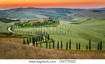 Sunset And Winding Road With Cypresses In Tuscany