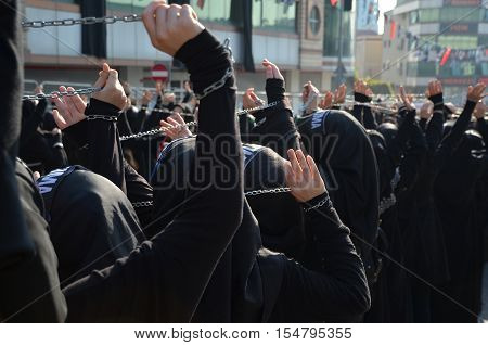 Istanbul Turkey - October 11 2016: Shiite Muslim women hold up their chained hands as they mourn during an Ashura procession. Turkish Shia Muslims mourning for Imam Hussain. Caferis take part in a mourning procession marking the day of Ashura in Istanbul'