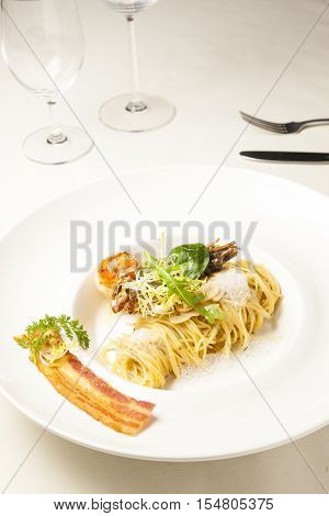 Pasta with shrimp and bacon on dining table