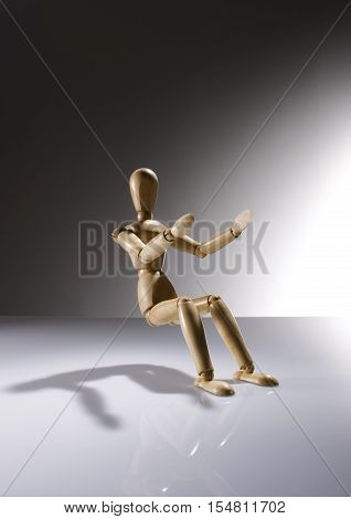 Wooden Dummy Doll sitting without a chair on gradient background