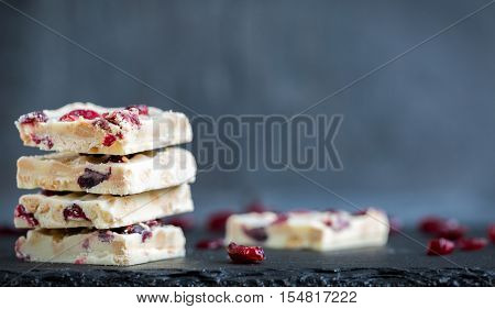 Homemade. white chocolate chunks with cranberries on black slate