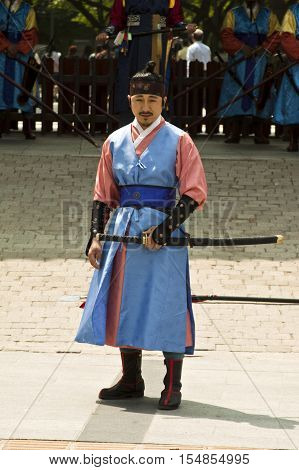 Seoul Korea - May 14 2015: Armed guards in traditional costume guard the entry gate at Deoksugung Palace a tourist landmark in Seoul South Korea