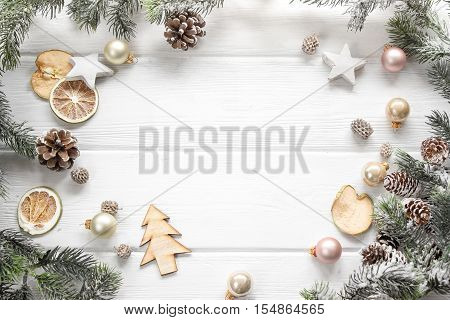 Christmas decoration of fir tree and conifer cone on wood background top view. Copy space