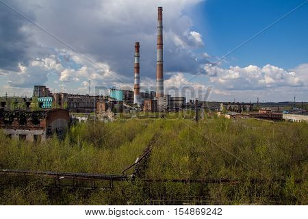 Abandoned factory of synthetic rubber overgrown by trees