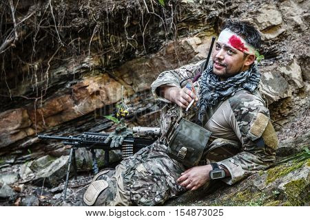 Wounded army ranger machine gunner in the mountains