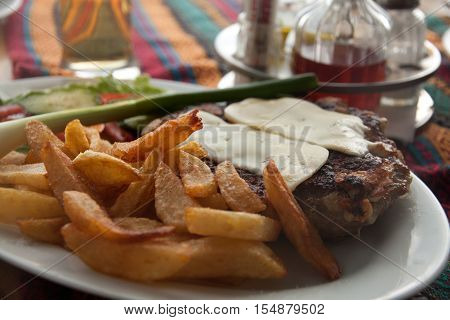 Traditional Macedonian food different kind of meat, salats, breads, beer and Rakia - krvavica sausage with shopska salad, shallow dof