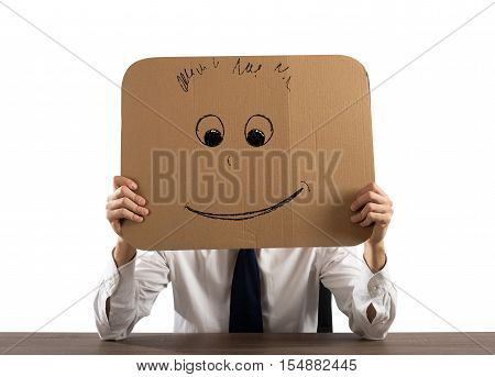 Businessman in the office holds a cardboard with a smiley face