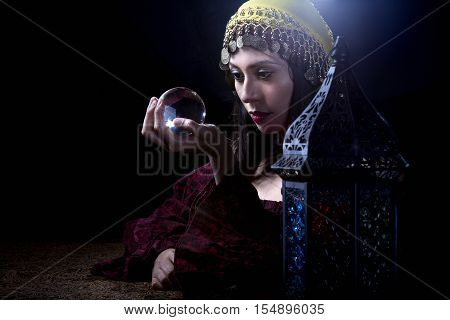 Psychic or diviner staring at a crystal ball to predict destiny or future. Astrology. Fortune Teller.