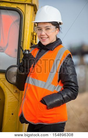 Beautiful female worker with radio at the factory