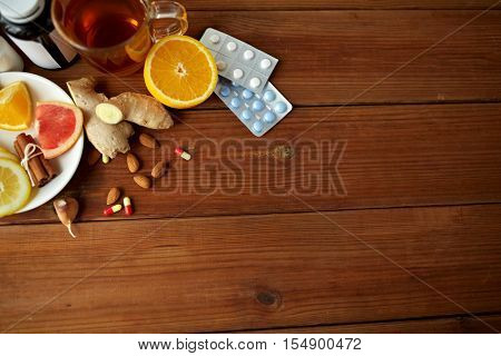healthcare and ethnoscience concept - traditional medicine and drug pills on wooden table