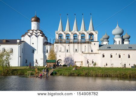 View of a old belfry and Church of the Intercession of the Tikhvin Uspensky monastery in the sunny october afternoon. Tikhvin Russia