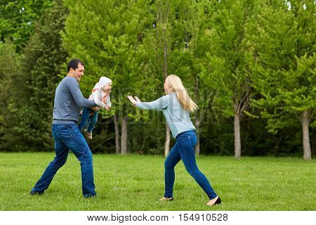 Happy family lifestyle. Mother dad and child in the park.