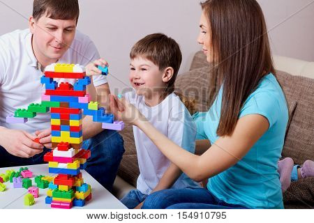 Happy Family  Playing With Colorful Blocks Inside At Home.