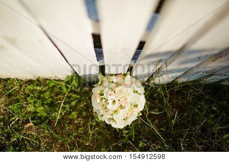 Wedding bouquet on white fense on ceremony place.Top view.