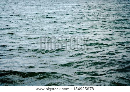 Dark blue background of water surface. Ocean water surface texture. Deep sea waves