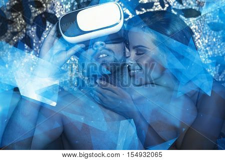 Young couple playing with VR headset at night in bed foreplay sexual fantasy glowing low polygons