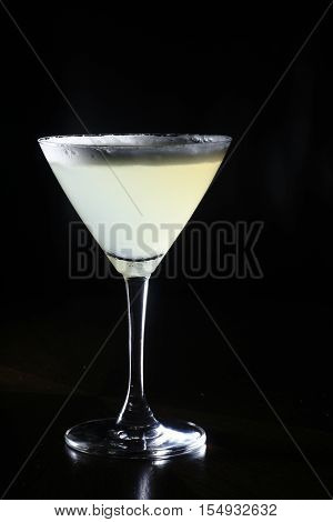 White cocktail with form on top against black background
