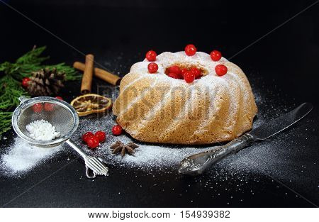 Christmas bundt cake with red berries on a black background