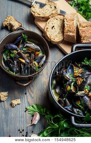Fresh ingredients to prepare mussels on old wooden table