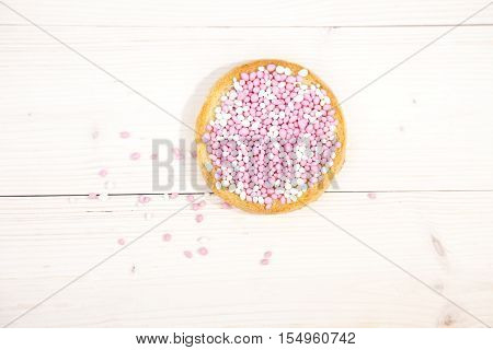 Traditional Dutch birth celebration biscuit with pink muisjes on wooden background