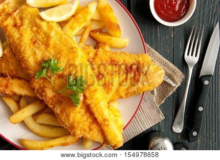 Close up of battered fish on a plate with chips