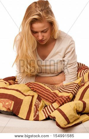 Woman Sitting On Bed Holding Belly Because Of The Pain In Stomac.