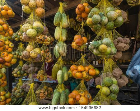 Tasty fresh colorful fruit hanging on a market stall in a small town.