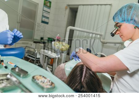 Woman At Dentist Clinic Gets Dental Treatment To Fill A Cavity In A Tooth. Dental Restoration And Co