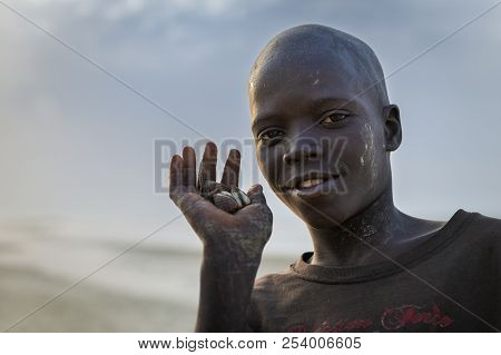 Orango Island, Guinea-bissau - February 2, 2018: Portrait Of A Young Boy Holding Cockles On His Hand