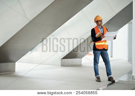 Construction Worker In Harthat And Vest Examining New Building