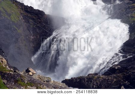 Kjosfossen waterfall flows down valley by the station on the train between Flam and Myrdal in Norway