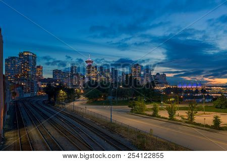 Vancouver Bc British Columbia Canada Downtown City Skyline By Railroad Tracks During Evening Blue Ho