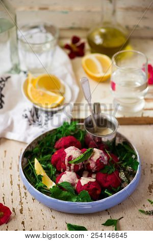 Beet Falafel With Tahina  Sauce And Green . Salad Selective Focus