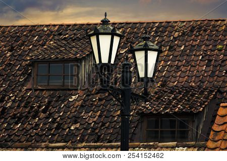Old Laterns In An Old Town, Red Roof With Windows On Background