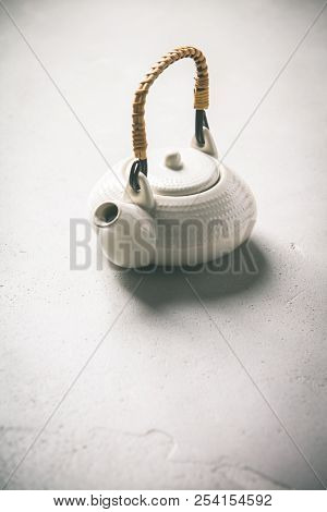 Ctramic teapot on concrete background- healthy life and relaxation concept