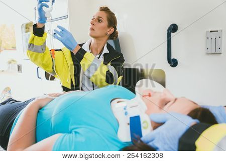 Medic taking care of injured woman with whiplash collar in ambulance
