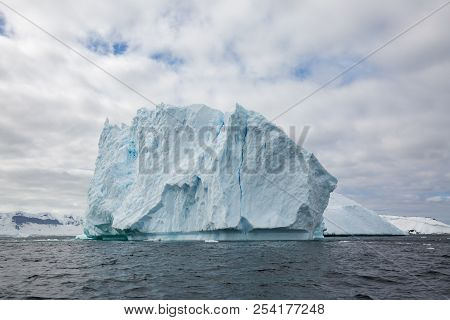 Icecaps In The Antarctica With Iceberg In The Ocean Swimming Around And Melting In The Sea