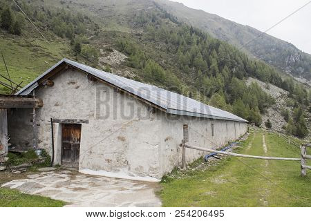 A Stable On A Mountain Full Of Trees And Green Grass