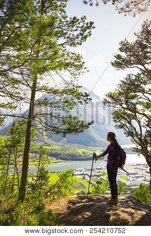 Girl Hiker With A Backpack And Trekking Pole Sitting And Looking On Romsdalsfjorden And Andalsnes, N