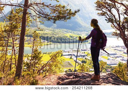 Girl Hiker With A Backpack And Trekking Pole Sitting And Looking On Romsdalsfjorden And Andalsnes, N